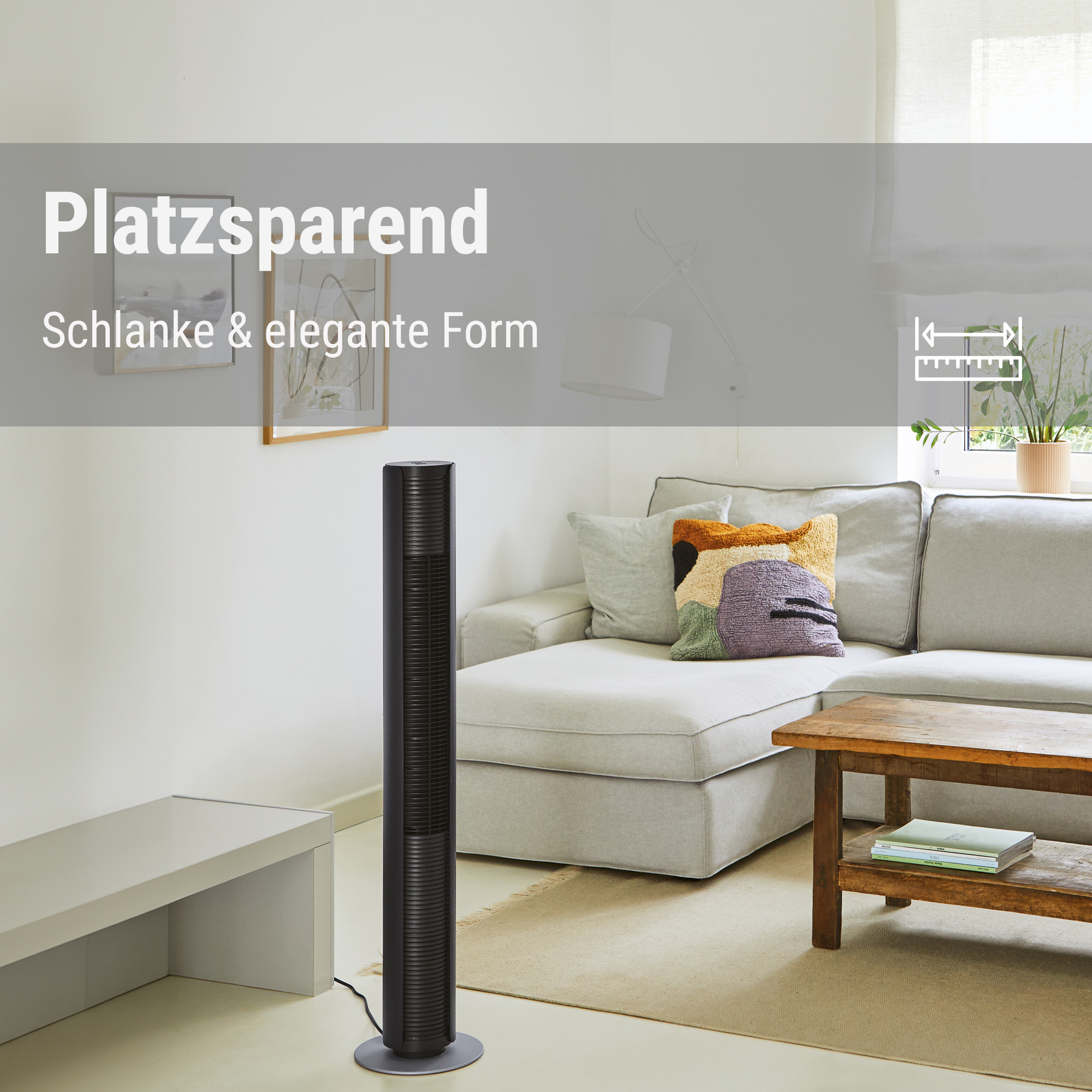 Schwarzer Turmventilator neben einem Sofa mit Kissen und Holztisch.