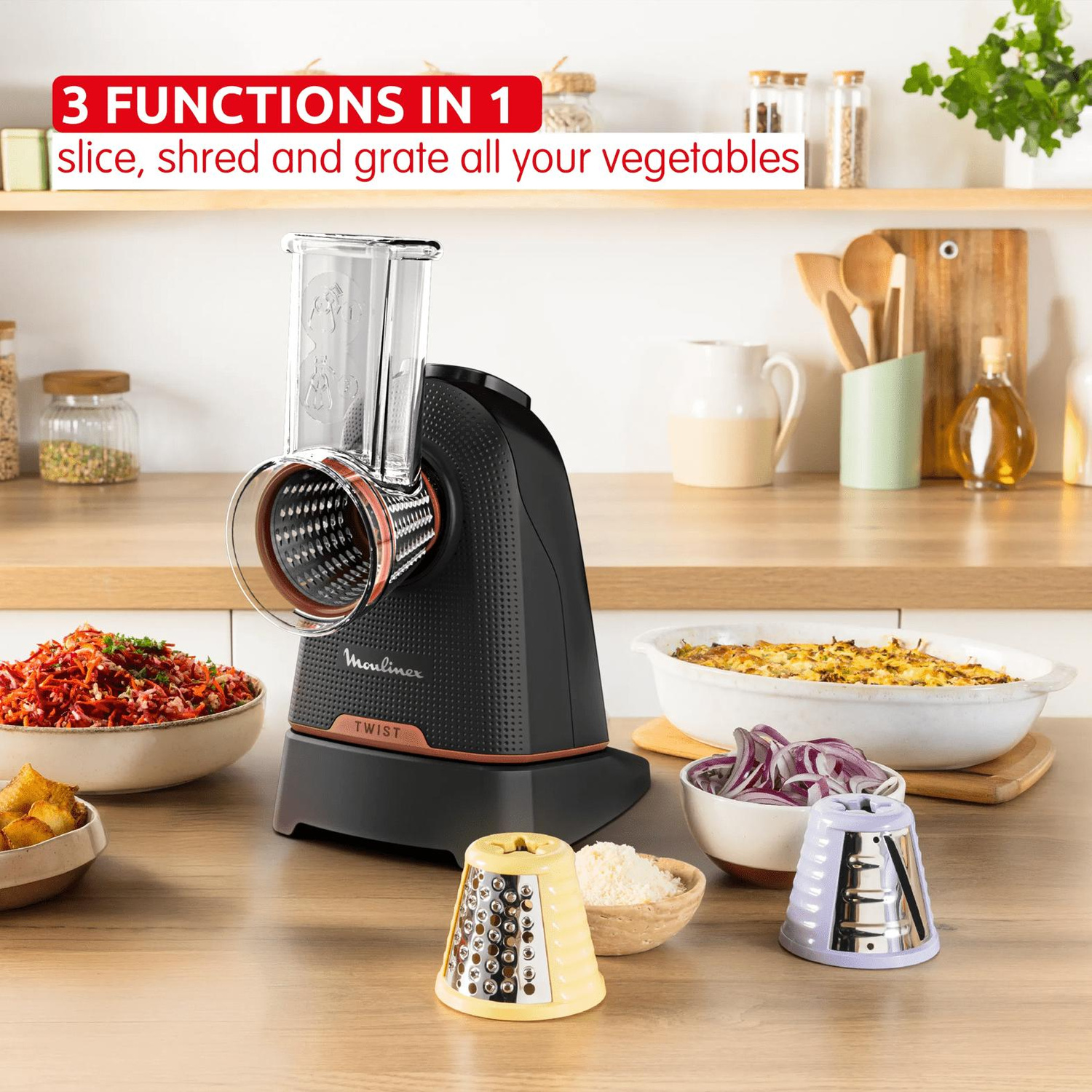 Robot da cucina con tre accessori e cibo preparato su un tavolo di legno.