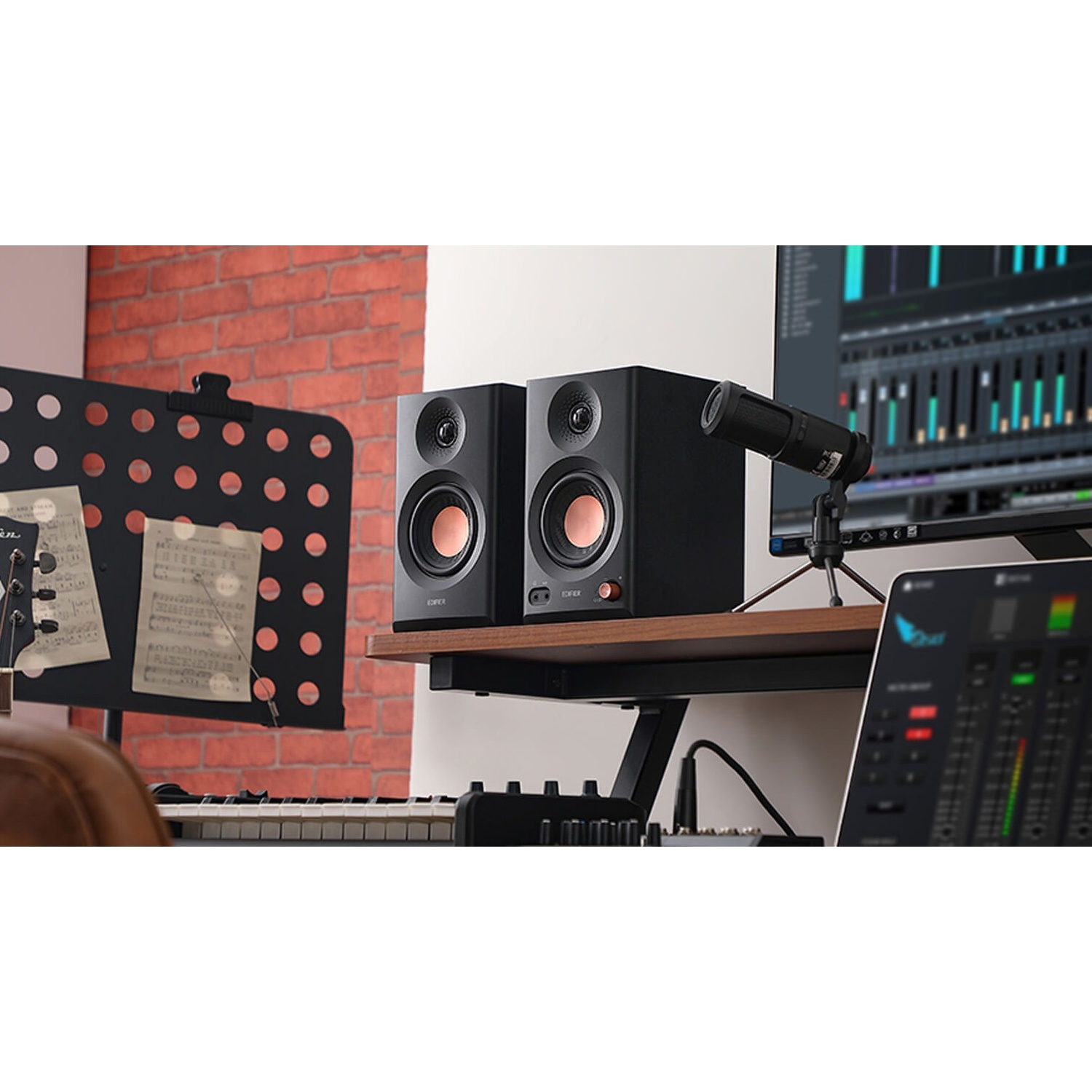 Due altoparlanti neri su uno scaffale con microfono, tastiera e mixer.