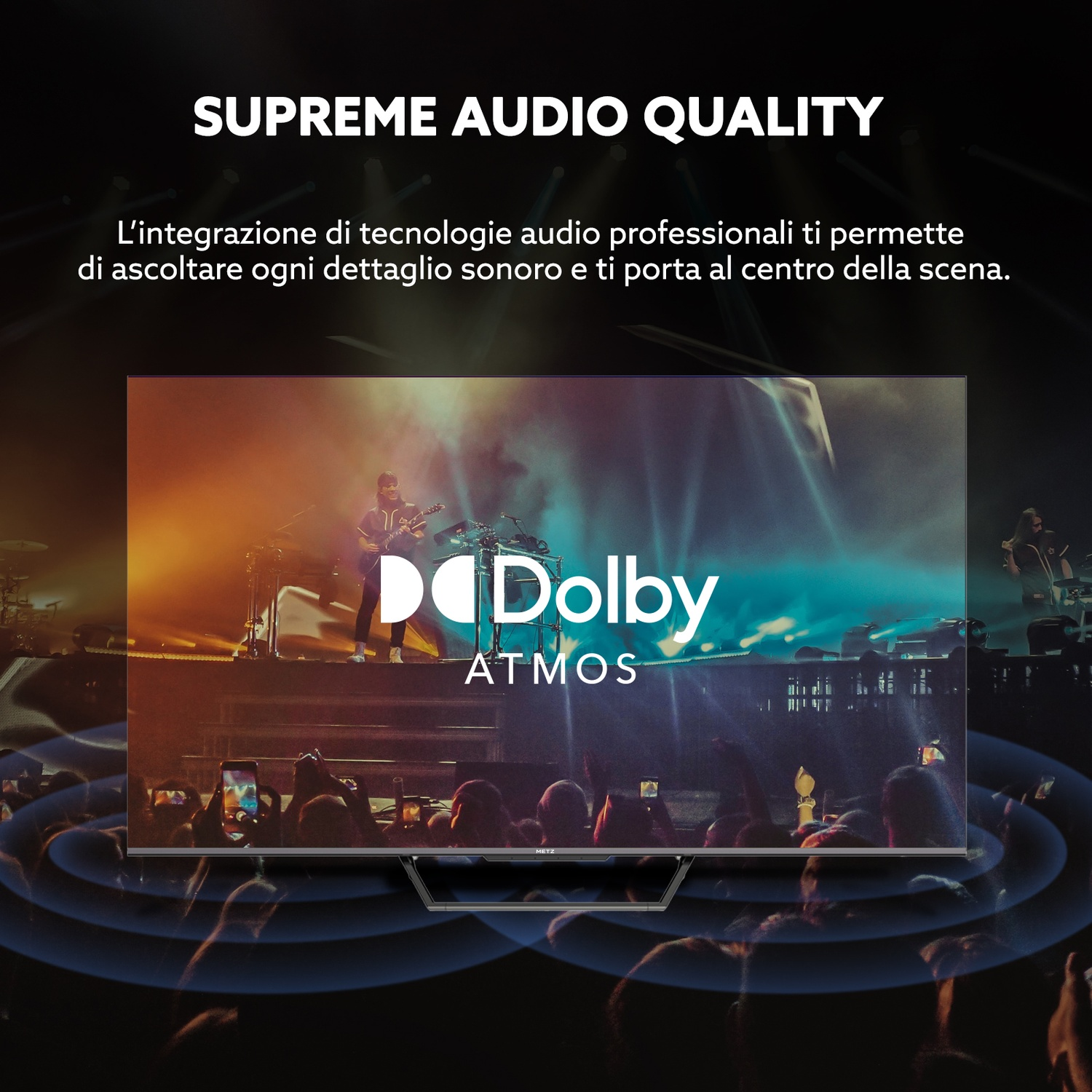 Schermo TV mostra concerto con logo Dolby Atmos, pubblico in primo piano.