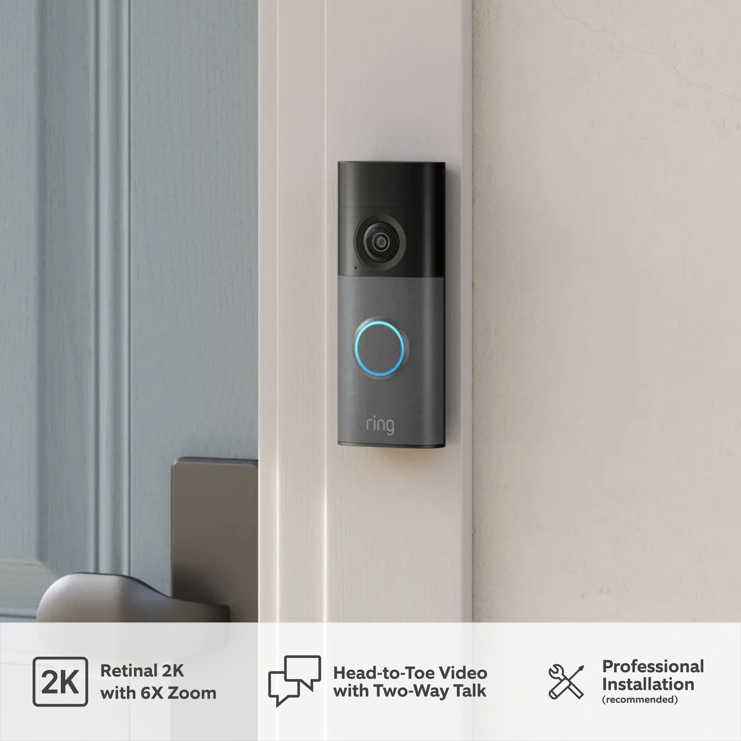 A dark Ring doorbell with a blue illuminated button on a white door.