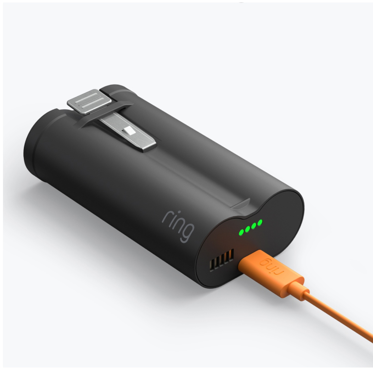 Batterie noire Ring en charge avec un câble USB orange. Quatre voyants verts indiquent la charge.