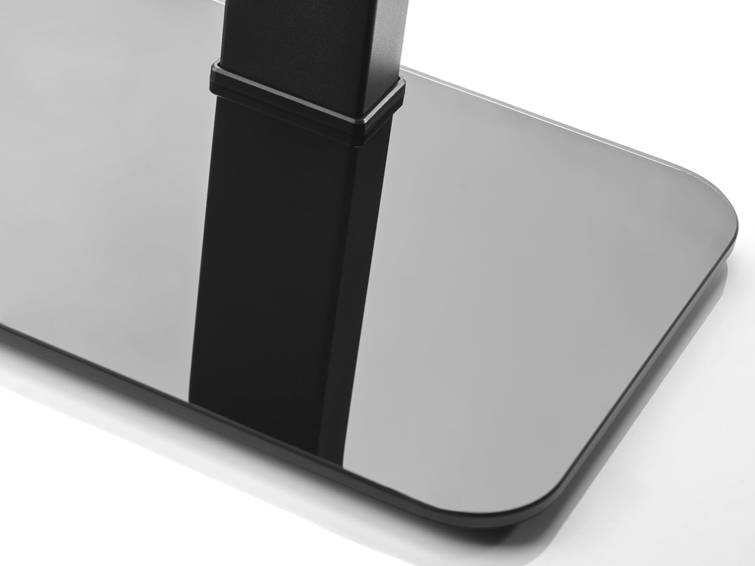 Soporte metálico negro con base de cristal negro brillante, iluminado en estudio.