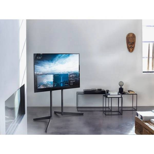Una sala de estar moderna presenta un televisor grande sobre un soporte.