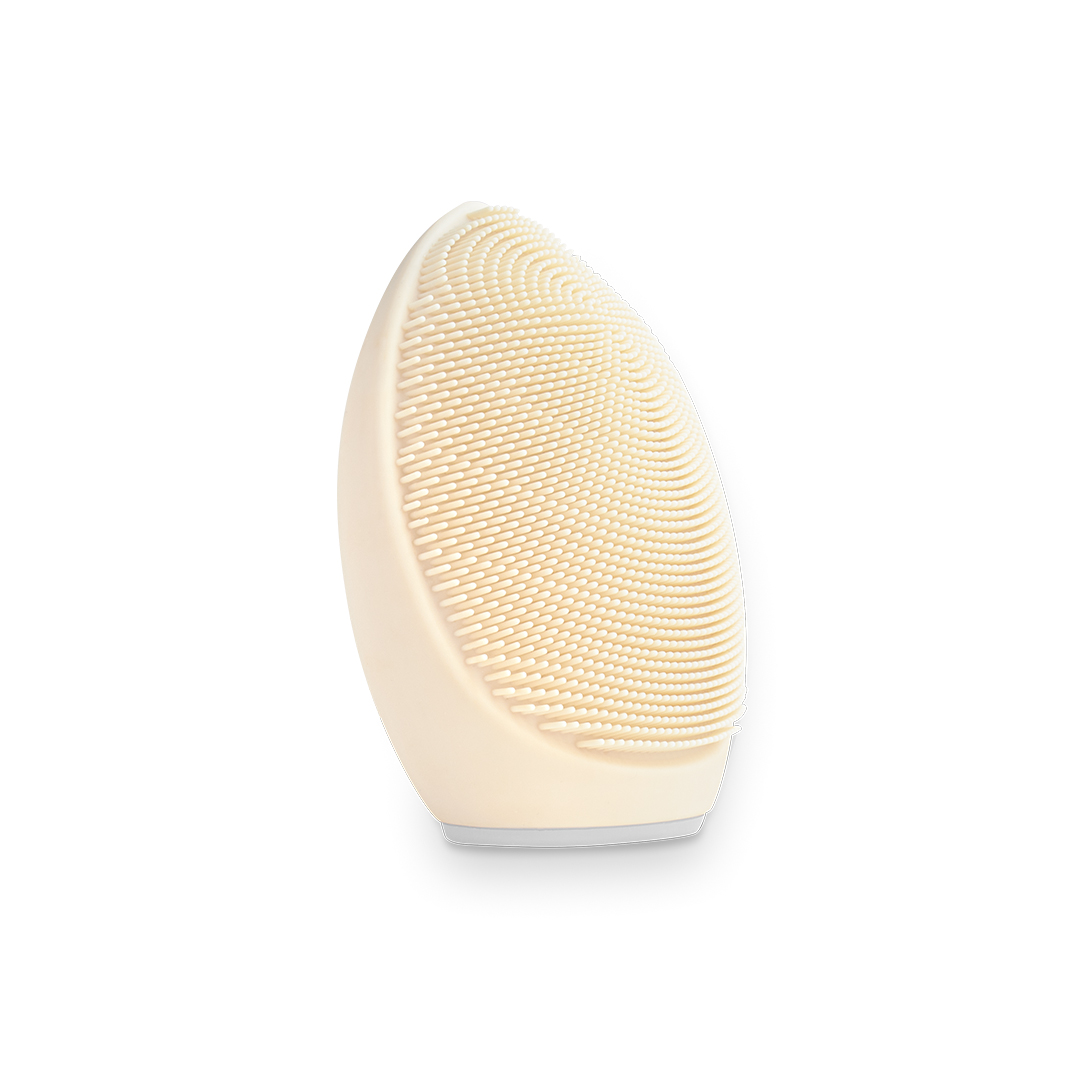 Cabezal de cepillo limpiador facial beige claro con cerdas de silicona sobre fondo blanco.