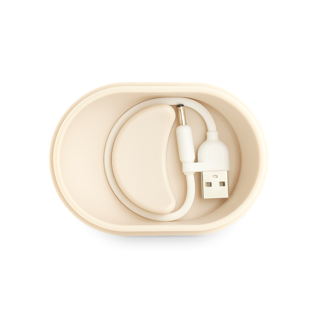 Un recipiente beige con un cable y enchufe USB blancos.