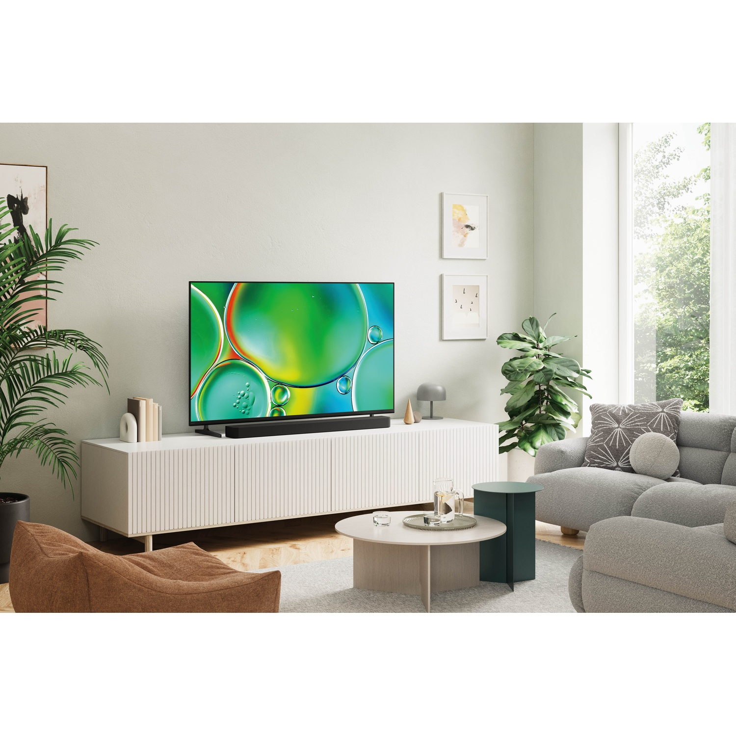 Moderne woonkamer met tv, planten, bank en zitzakken.