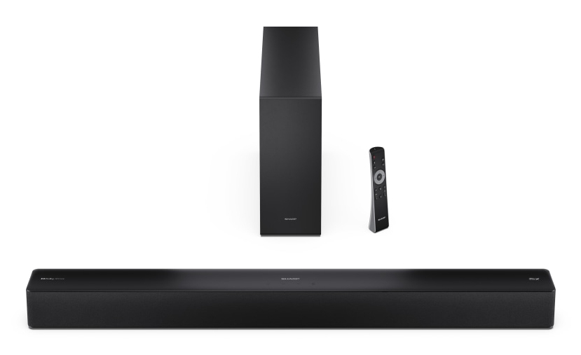 Barra de sonido, subwoofer y mando a distancia negros sobre fondo blanco.