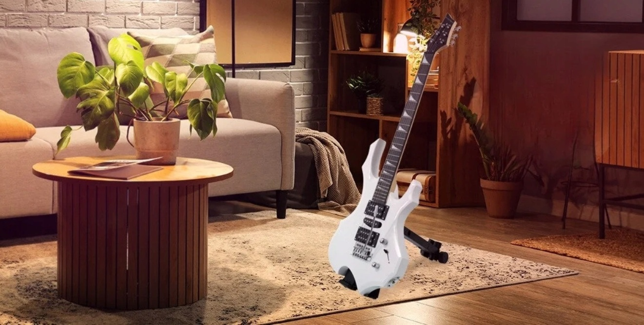 Biała gitara elektryczna stoi na statywie w salonie.