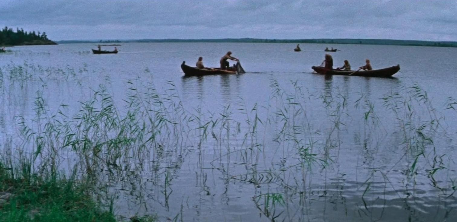 Mehrere Kanus auf einem See mit Fischern. Schilf im Vordergrund.