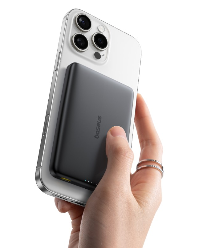 Bir el, arkasına siyah manyetik power bank takılı gümüş bir akıllı telefon tutuyor.