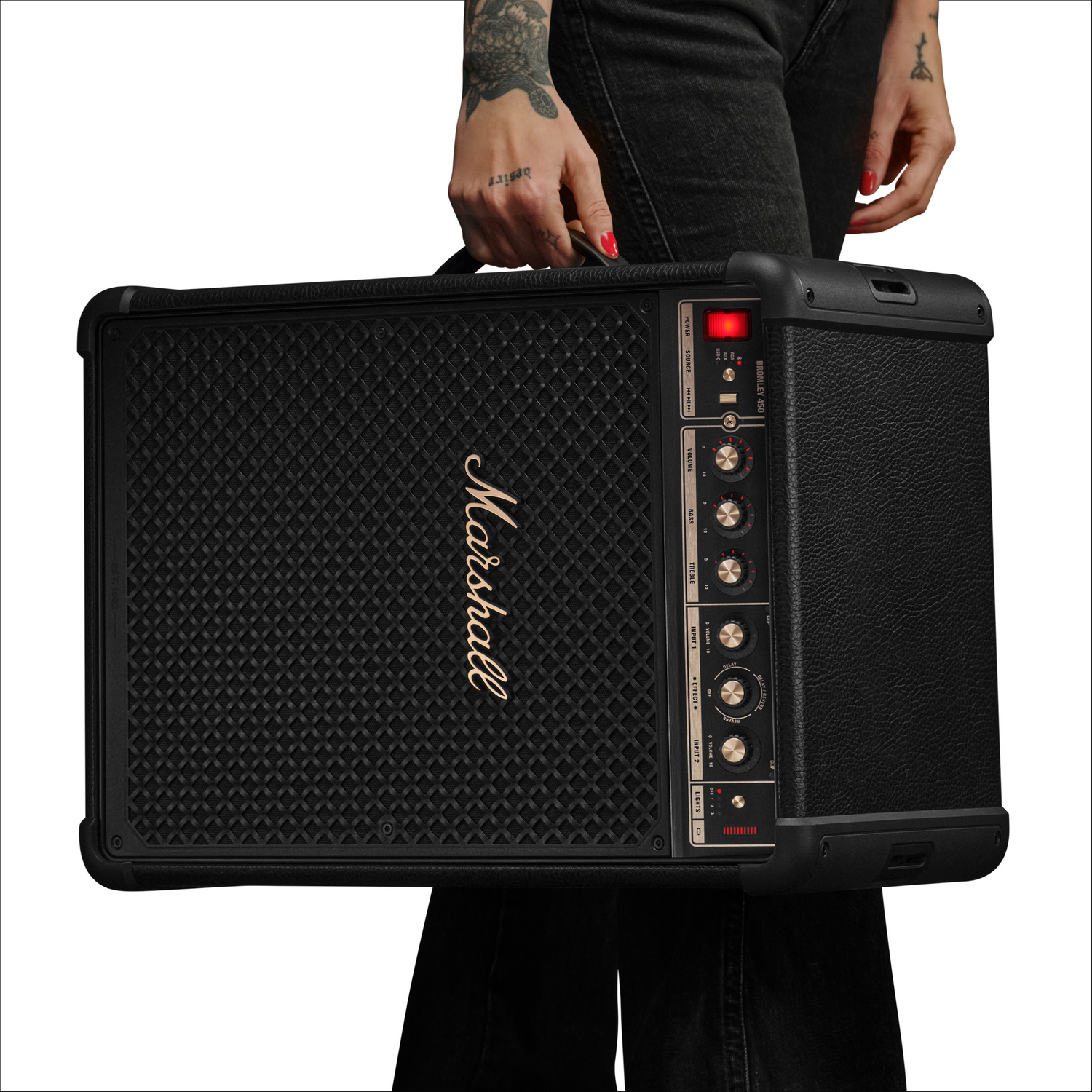 Amplificador Marshall negro con controles es llevado por una persona.