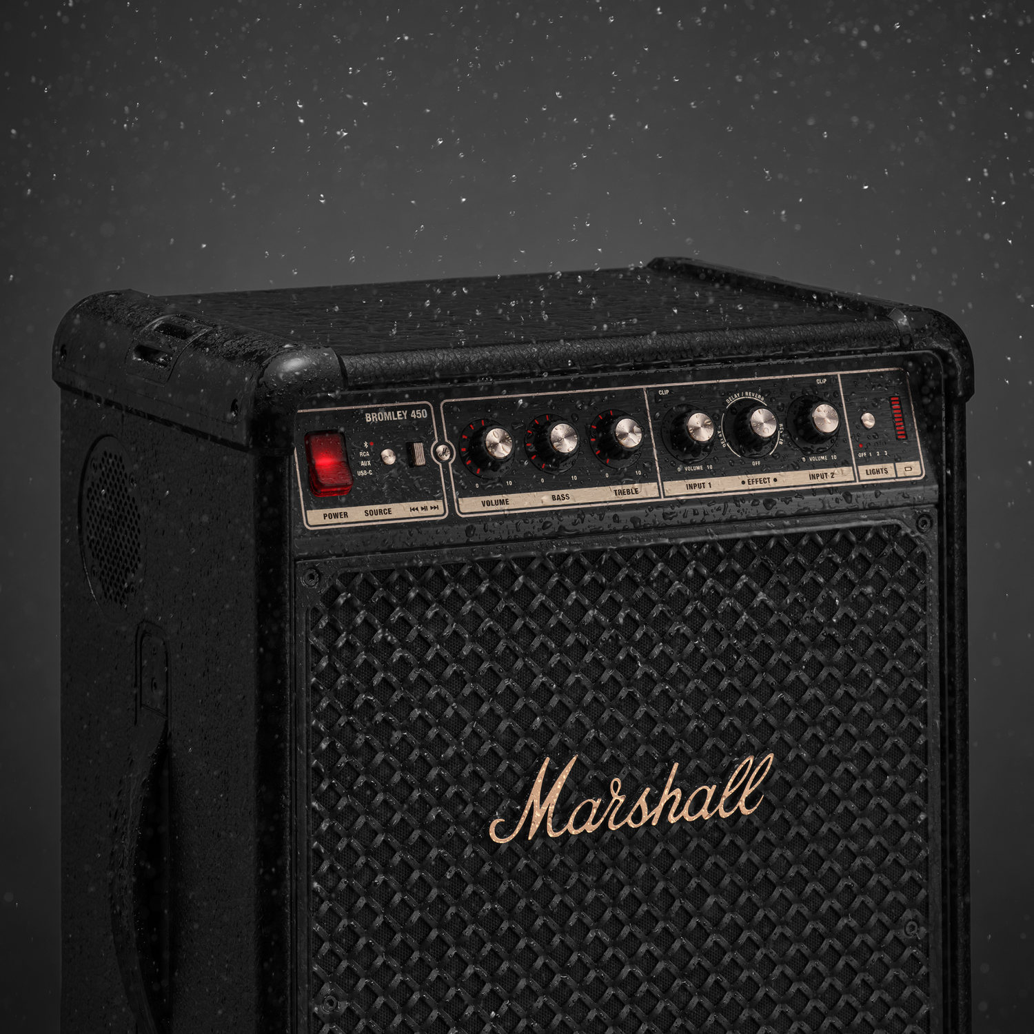 Amplificador Marshall negro con perillas y altavoz bajo la lluvia.