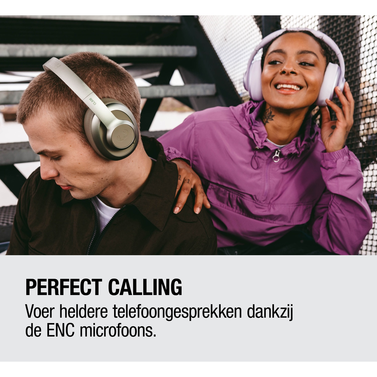 A man in silver headphones and a woman in purple headphones smile.