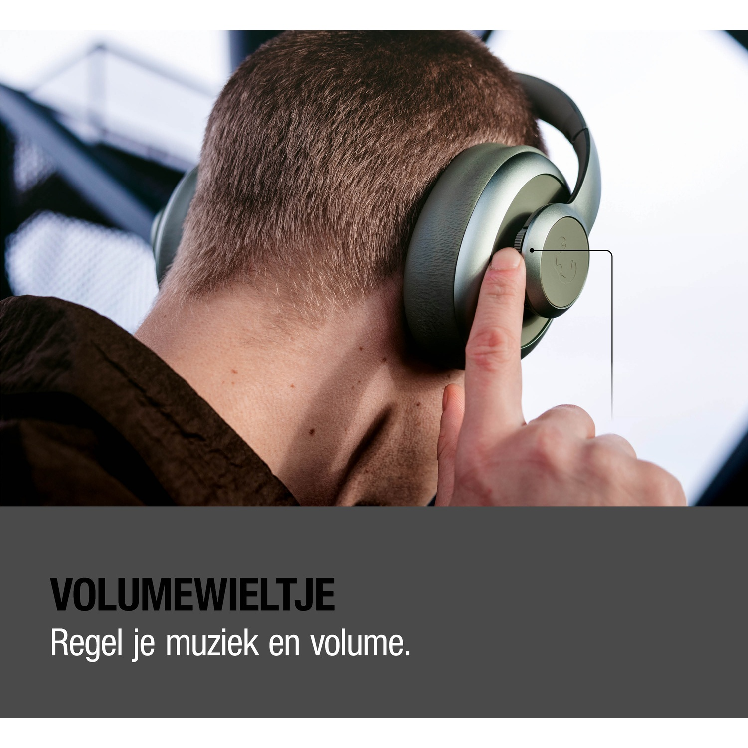 Man met koptelefoon bedient de volumeknop.