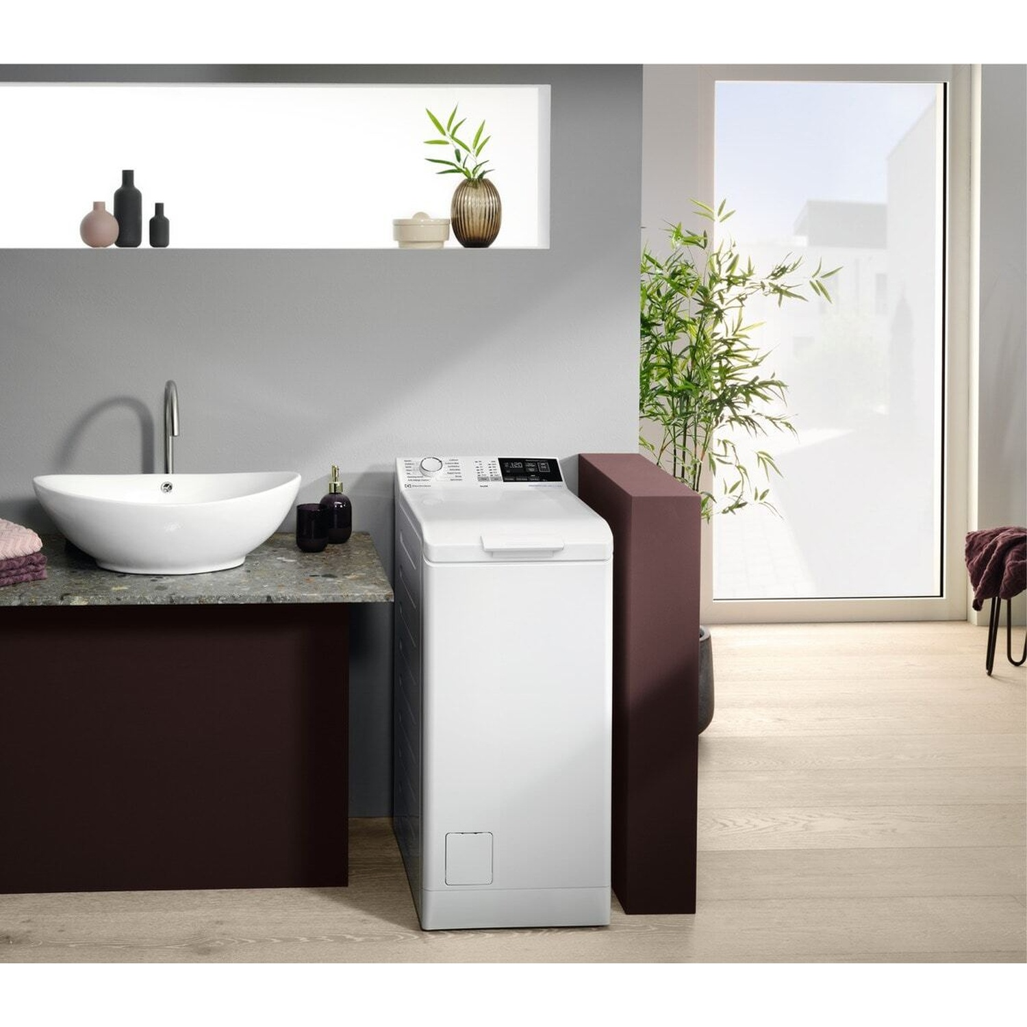 Una lavasciuga bianca accanto a un lavandino con mobile scuro.