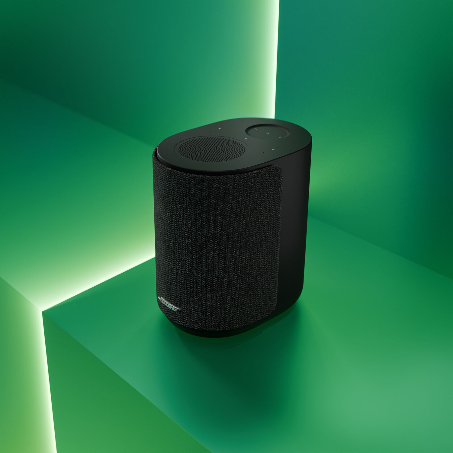 Black Bose speaker on a green geometric surface with neon lighting.
