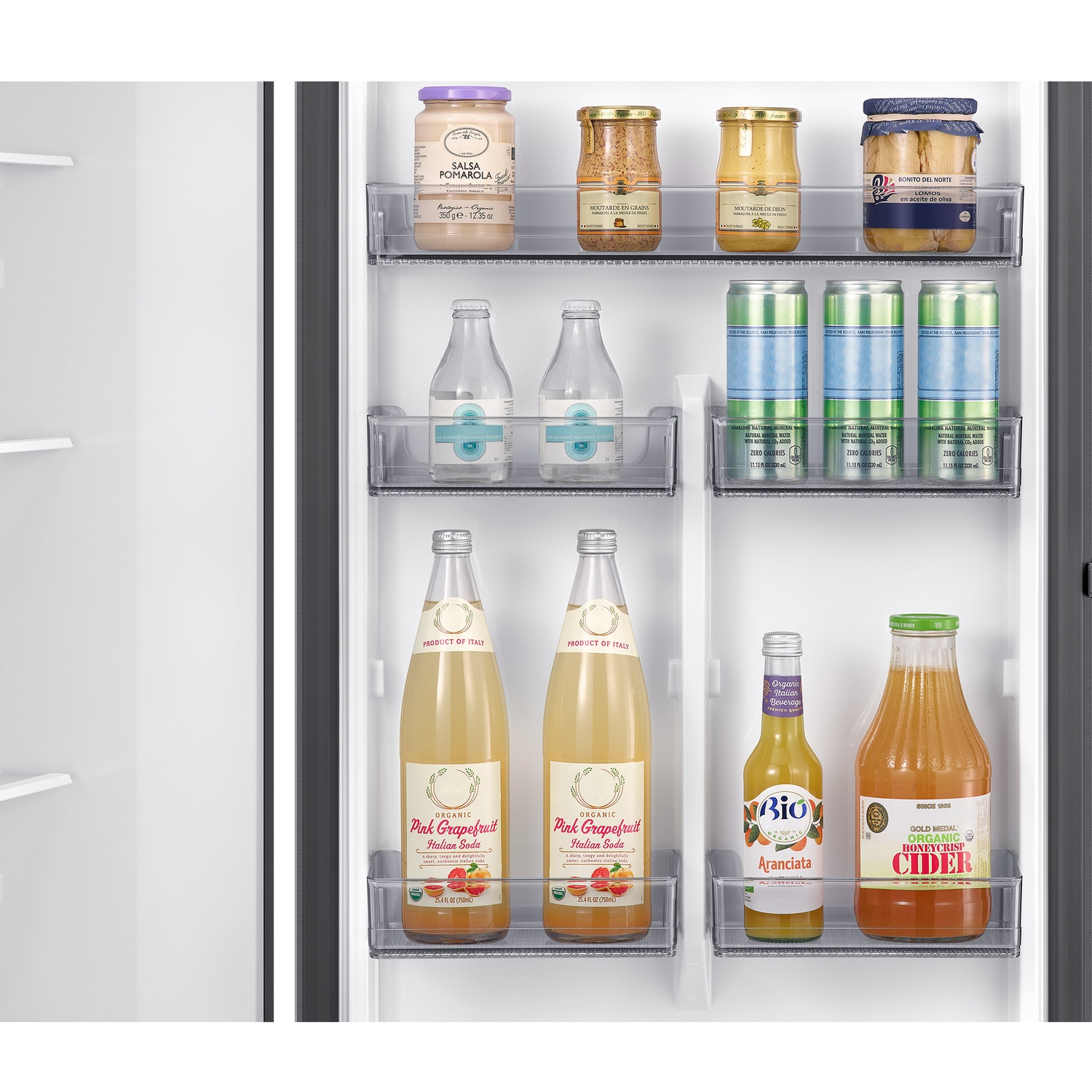 Puerta de refrigerador con frascos, latas y botellas, incluyendo salsa Pomarola, mostaza y aceitunas.