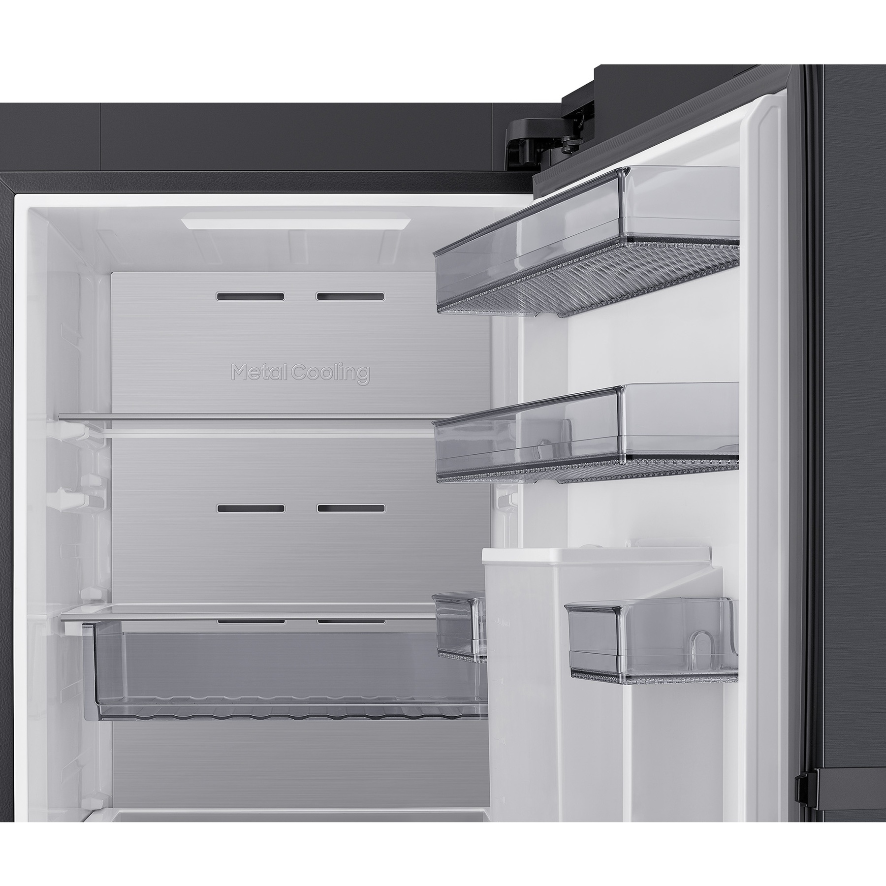 Interior de un refrigerador moderno con paneles de enfriamiento metálicos y cajones transparentes.
