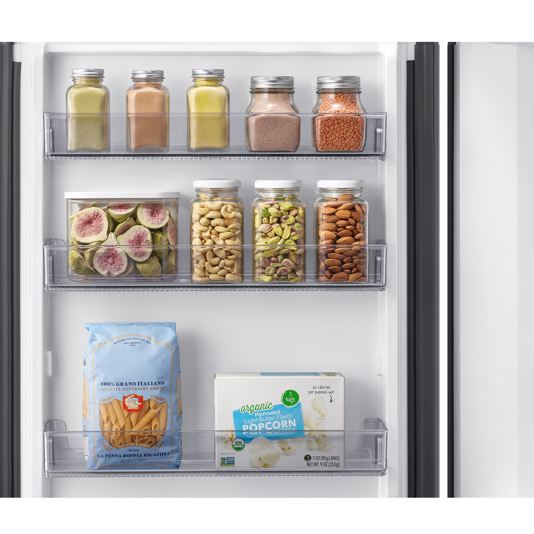 Puerta de refrigerador con frascos de frutos secos y frutas secas, pasta y palomitas.