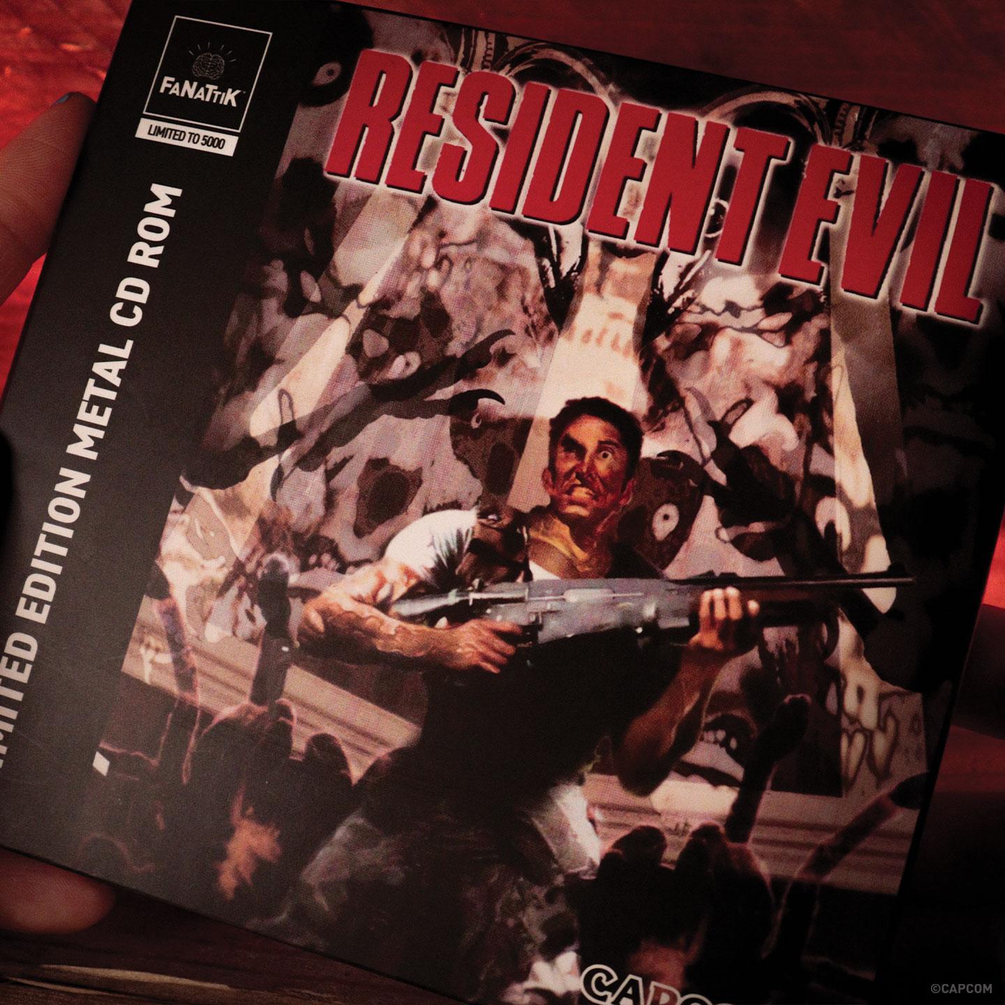 Funda de CD-ROM de Resident Evil con un hombre con rifle rodeado de monstruos.