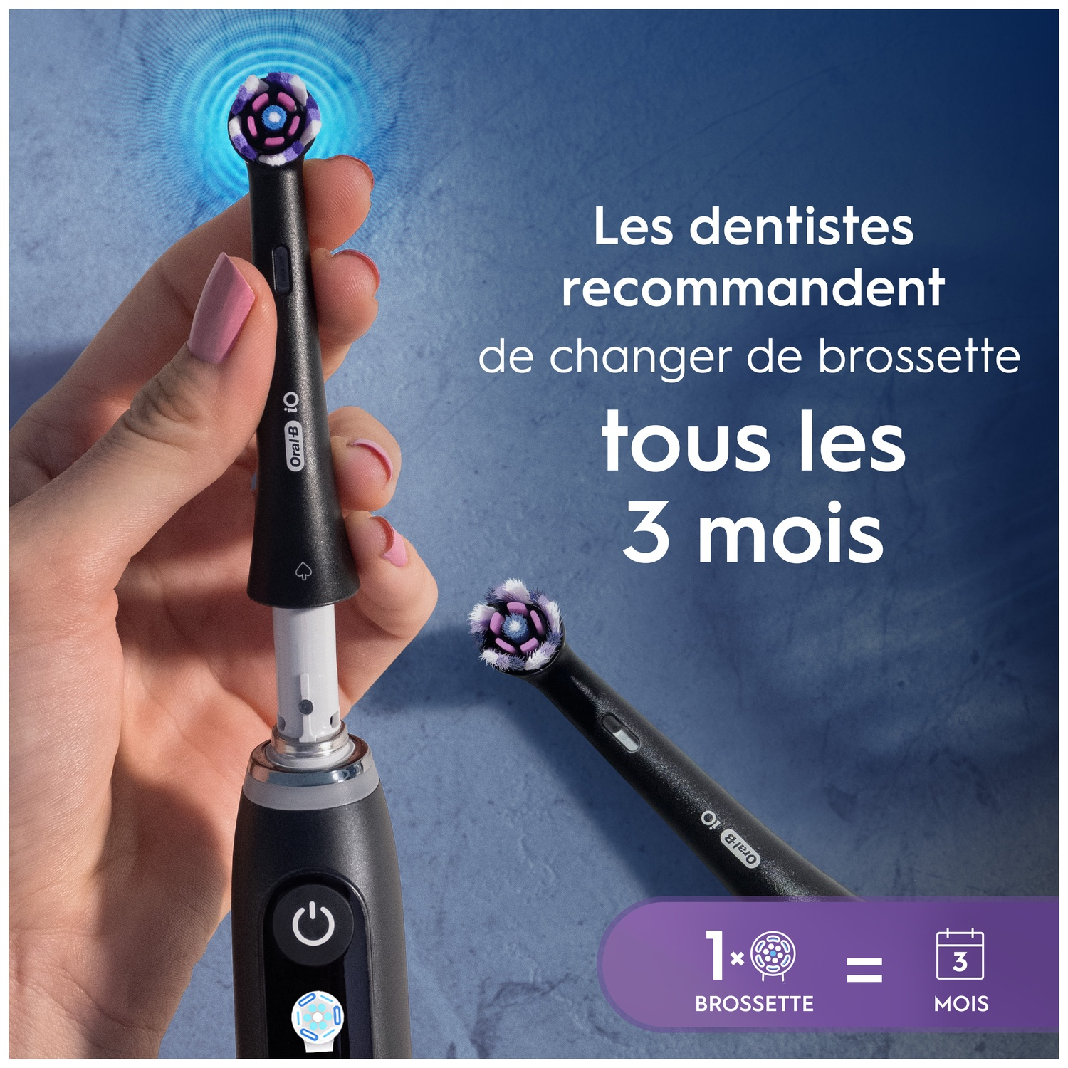 Une main tient une brosse à dents électrique, une tête de brosse est retirée.