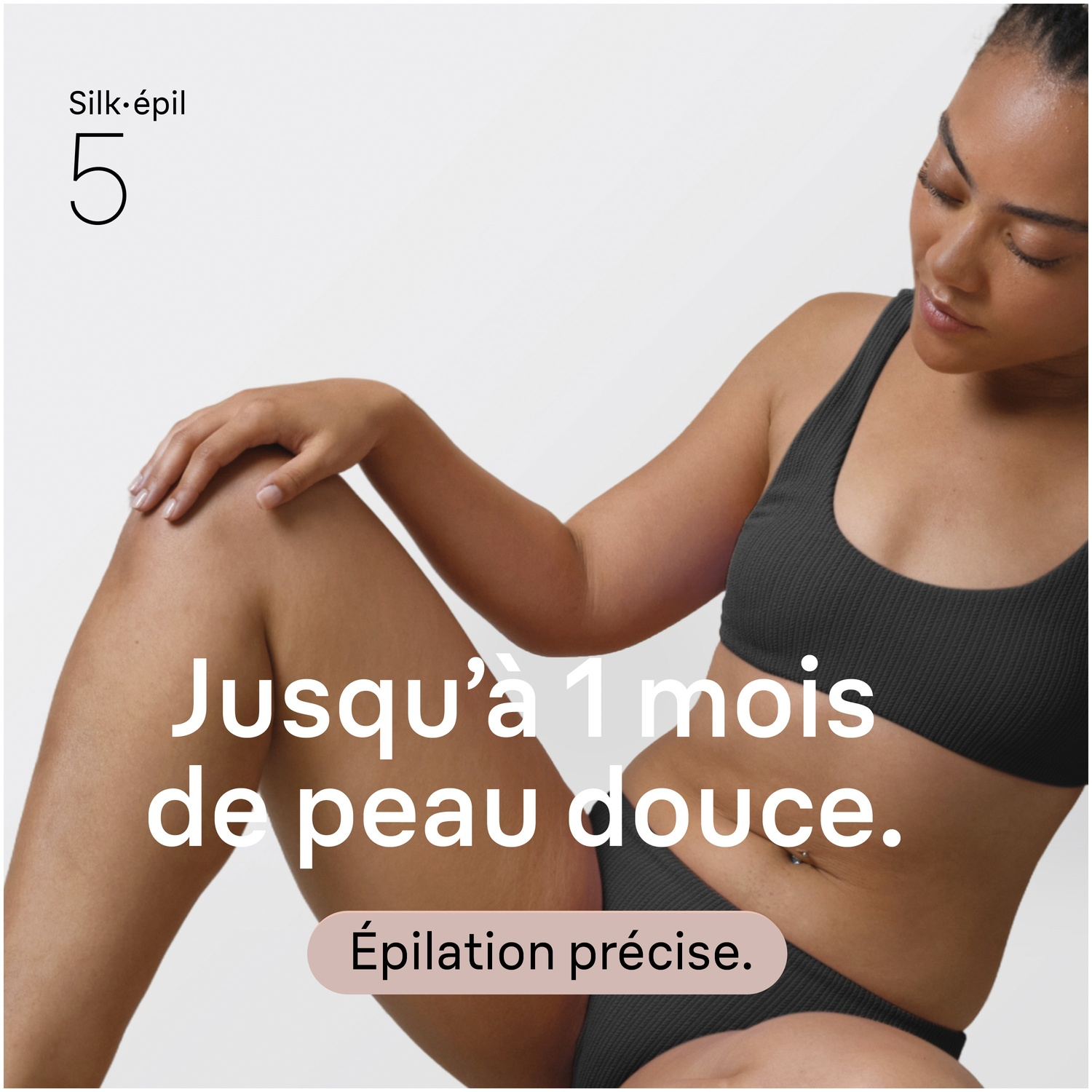 Femme en lingerie noire assise, texte sur peau douce et soyeuse.