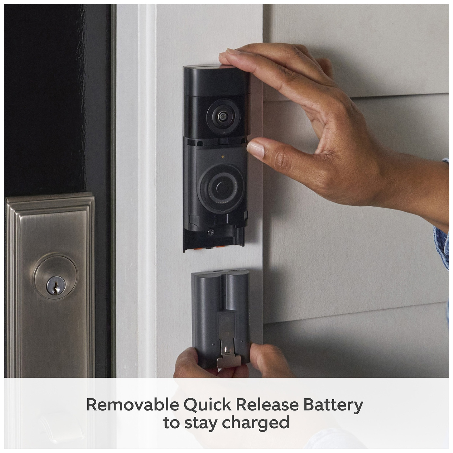 Hands replacing a removable battery for a doorbell camera.