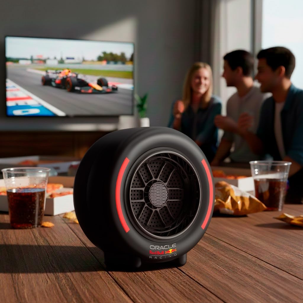Enceinte Red Bull F1 sur table avec pizza, boissons et amis regardant une course.