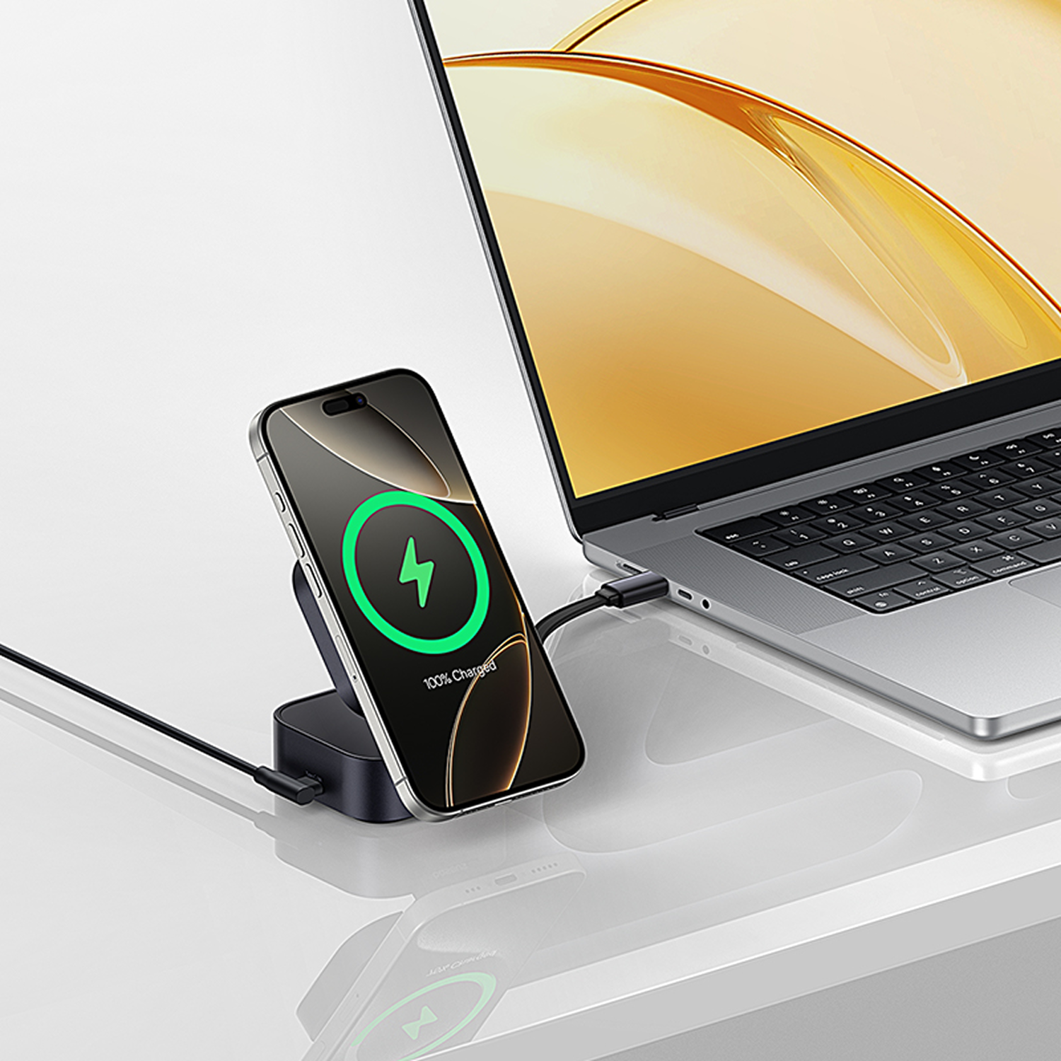 Un smartphone se carga en un soporte, conectado a un portátil.