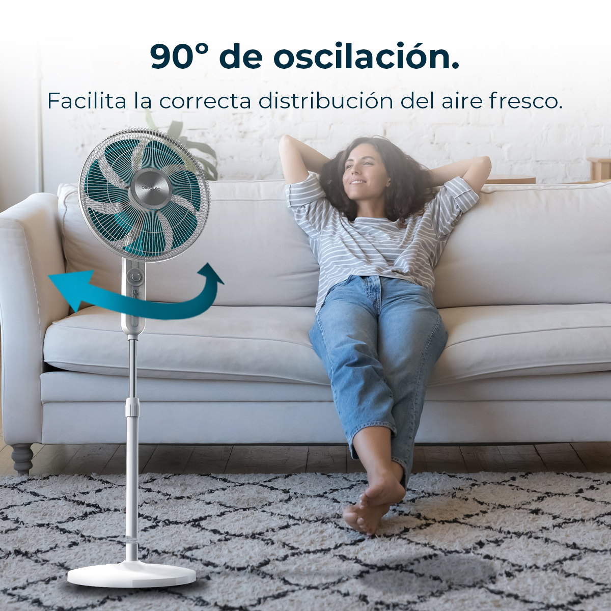Un ventilador con oscilación de 90° enfría a una mujer en un sofá.
