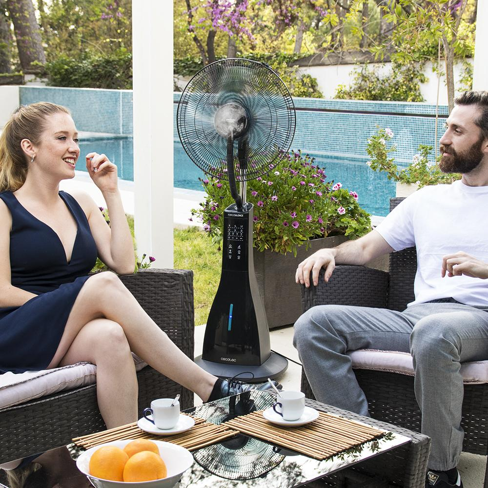 Una pareja sentada al aire libre en una mesa con tazas y naranjas junto a<lt/>/br<gt/><lt/>/br<gt/>