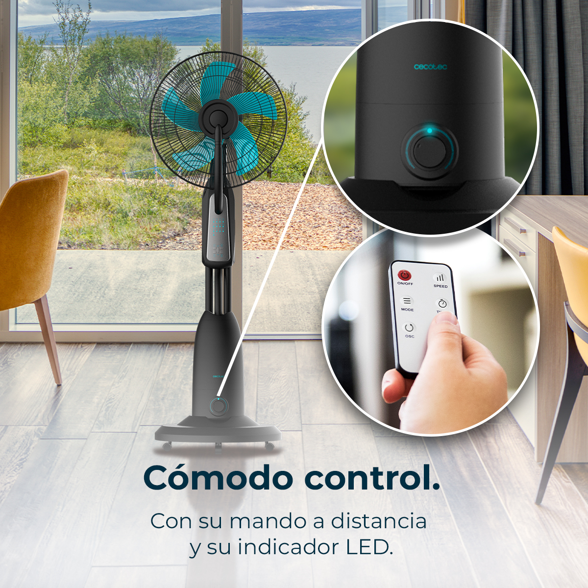 Un ventilador de pie negro con aspas azules está en primer plano. Junto a él, una ventana con vistas a la naturaleza y una mesa con silla.