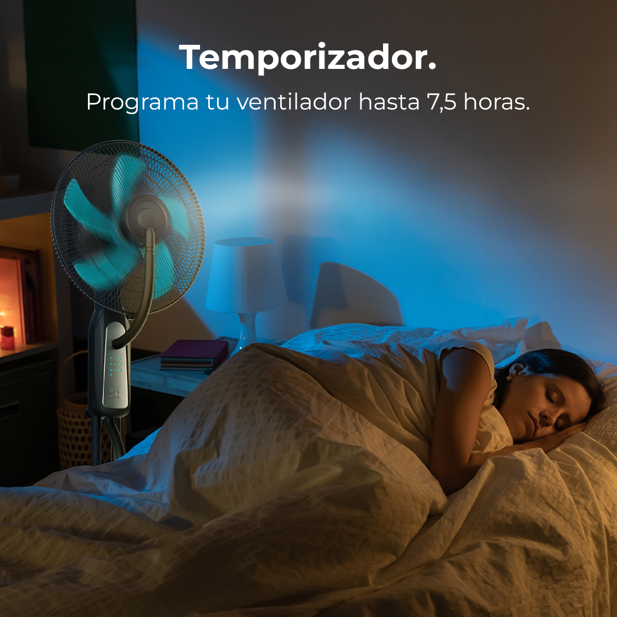 Una mujer duerme en la cama mientras un ventilador funciona con luz azul.