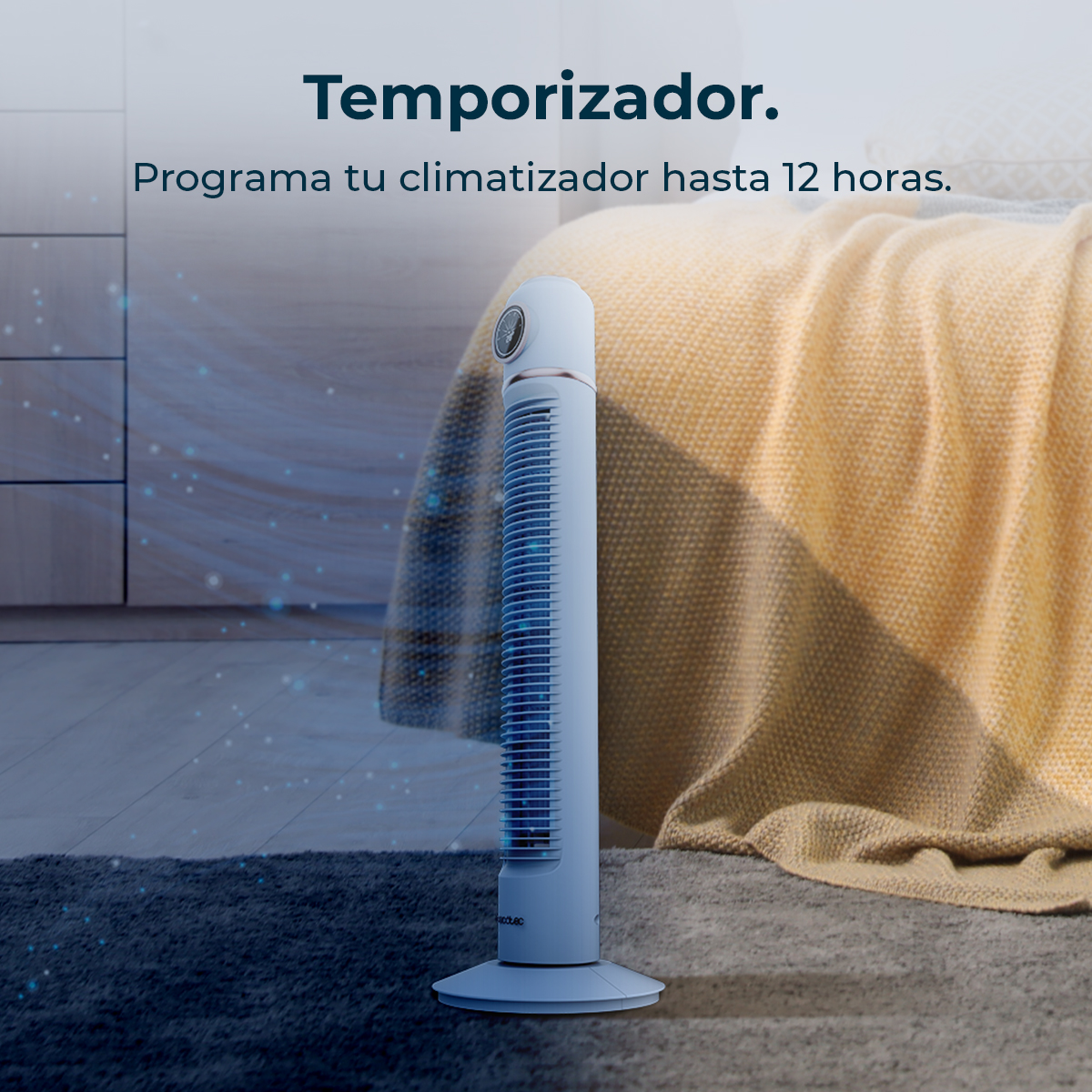 Un ventilador de torre blanco sobre alfombra frente a cama con manta amarilla.