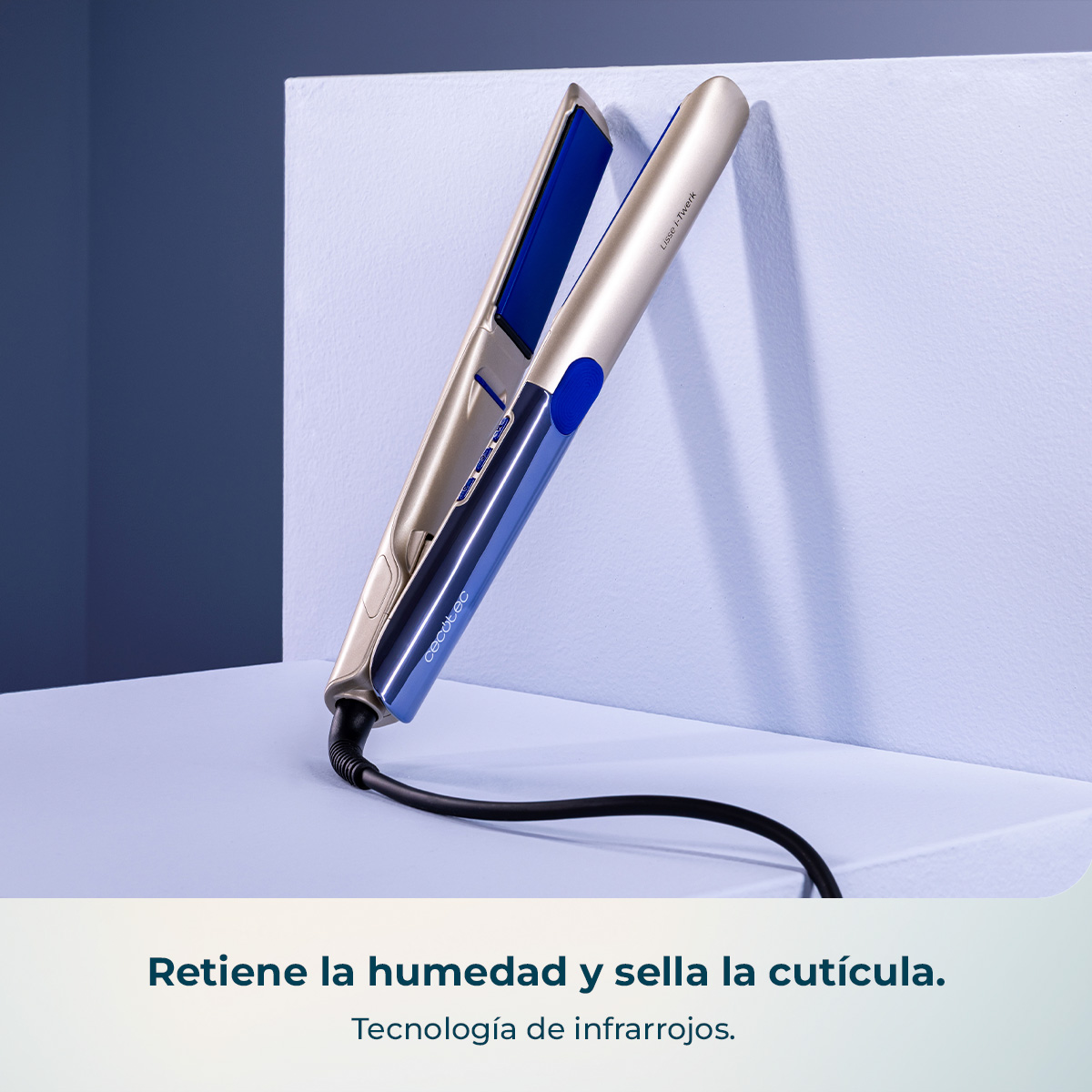 Un alisador de pelo dorado y azul con cable sobre pedestal blanco, fondo oscuro.