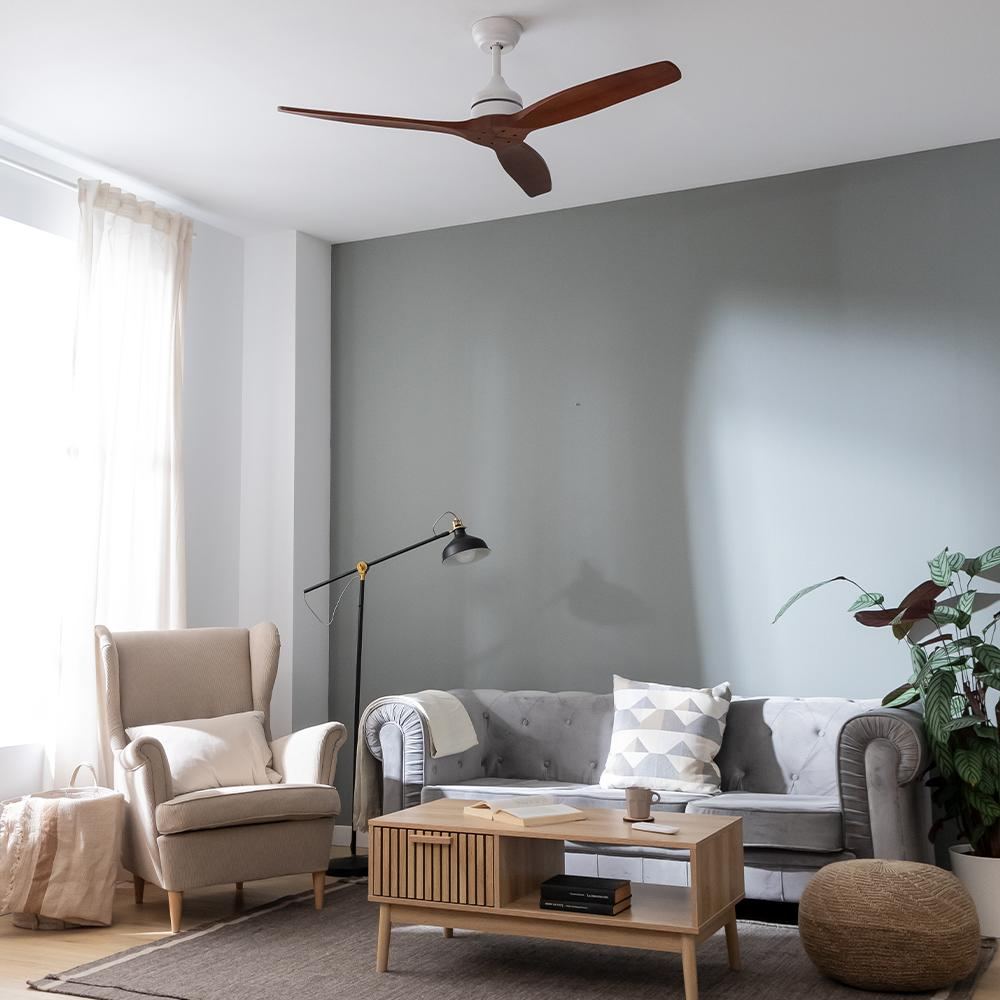Una sala de estar moderna con sofá gris, sillón, mesa de centro, lámpara de pie y ventilador de techo.