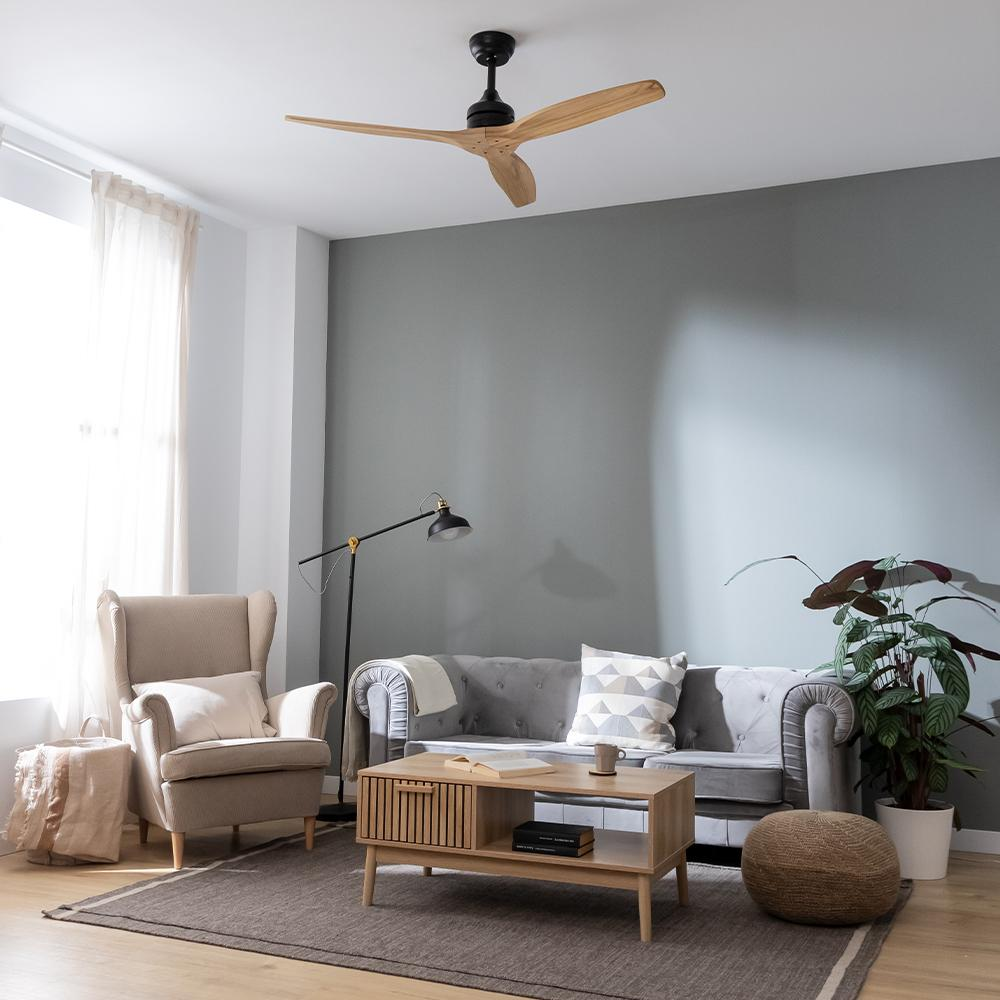 Una sala de estar con sofá, sillón, mesa de centro, lámpara y ventilador de techo.