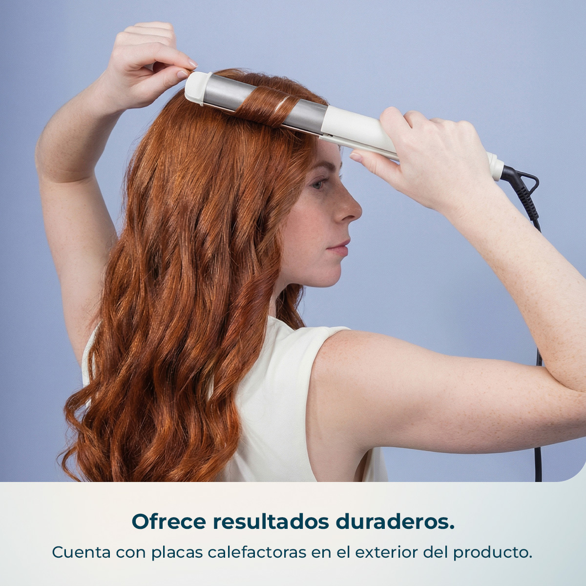 Mujer de pelo rojo usa un rizador blanco en su cabello sobre fondo azul.