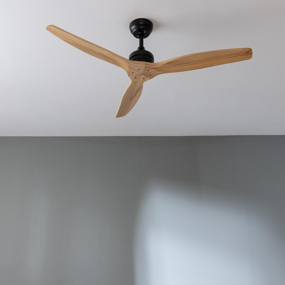 Un ventilador de techo moderno con tres aspas de madera y carcasa negra.