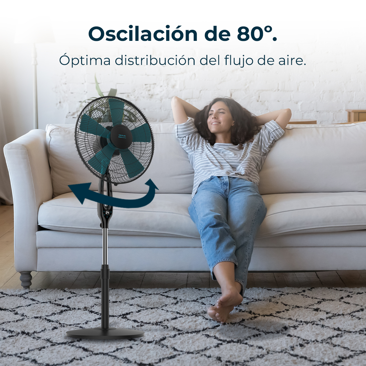 Un ventilador oscila mientras una mujer se relaja en un sofá.