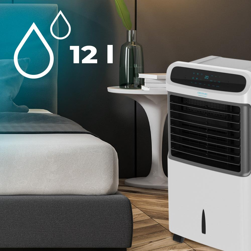Un enfriador de aire blanco junto a una cama, con indicador de 12L.