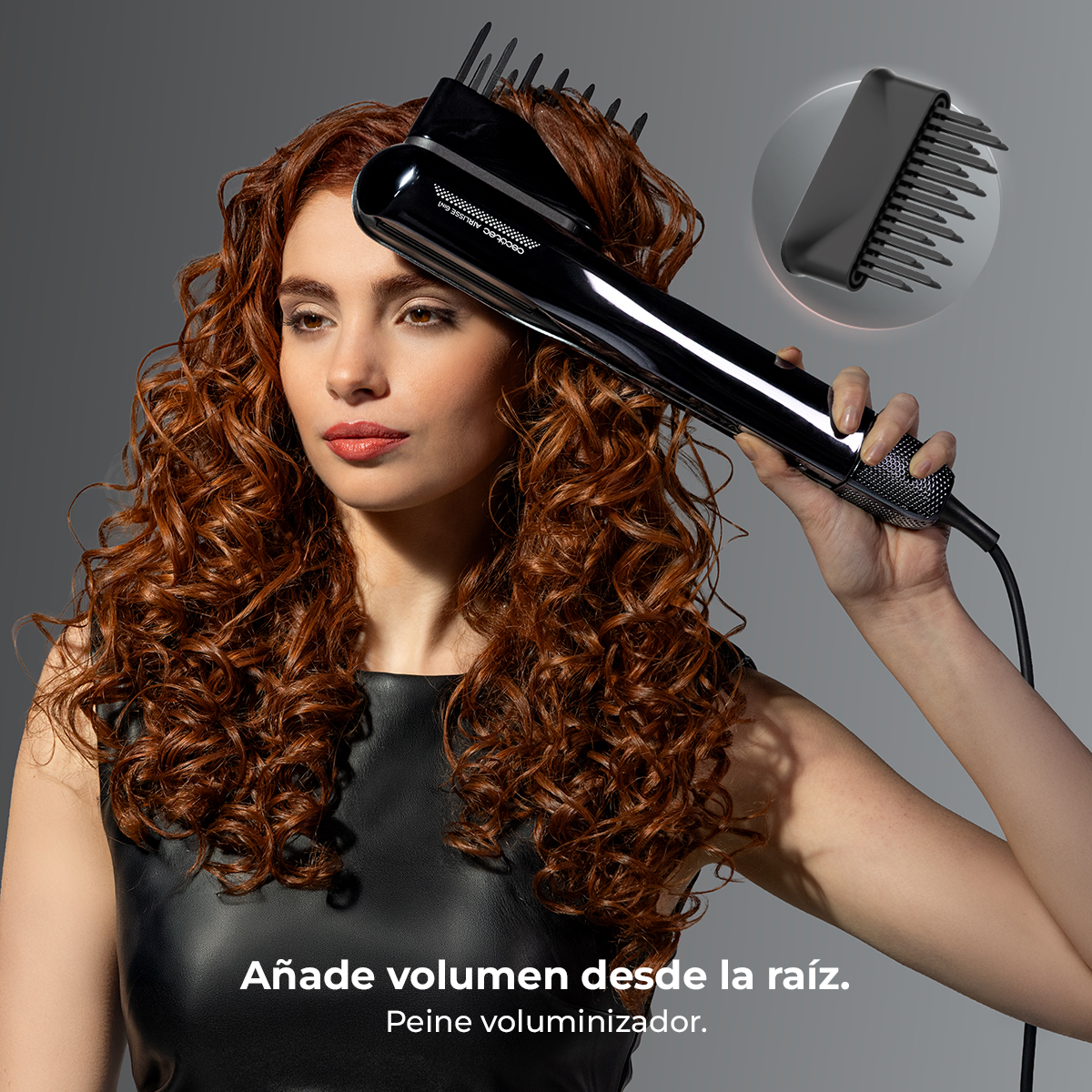Mujer con pelo rojo rizado usa un secador negro con accesorio de peine.