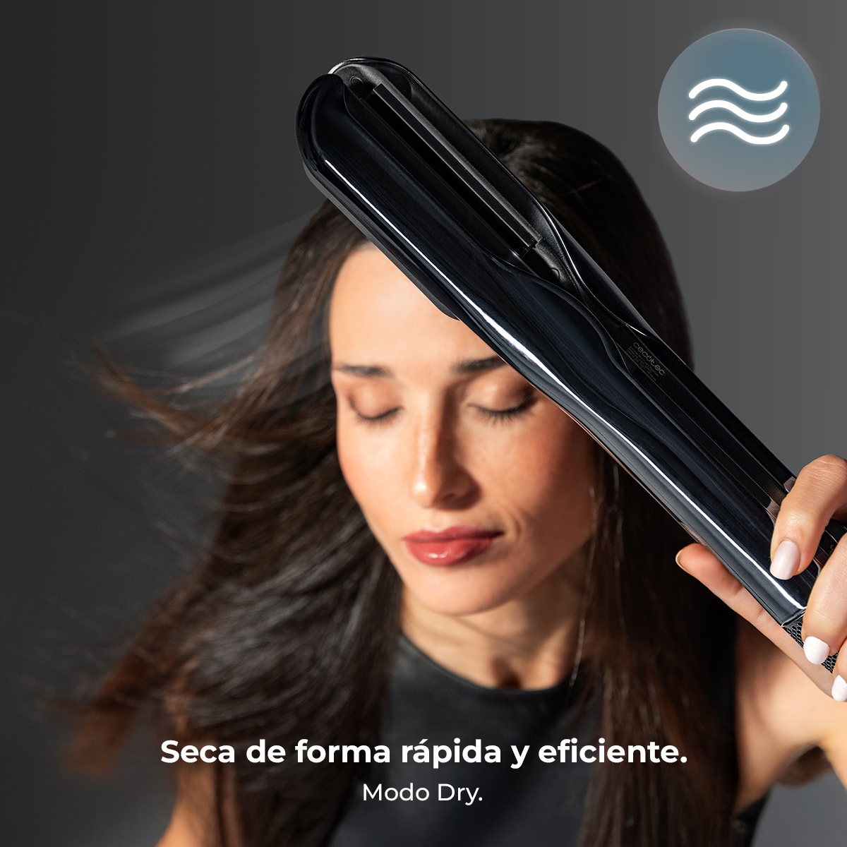 Una mujer usa un alisador de pelo negro. Sus ojos están cerrados.