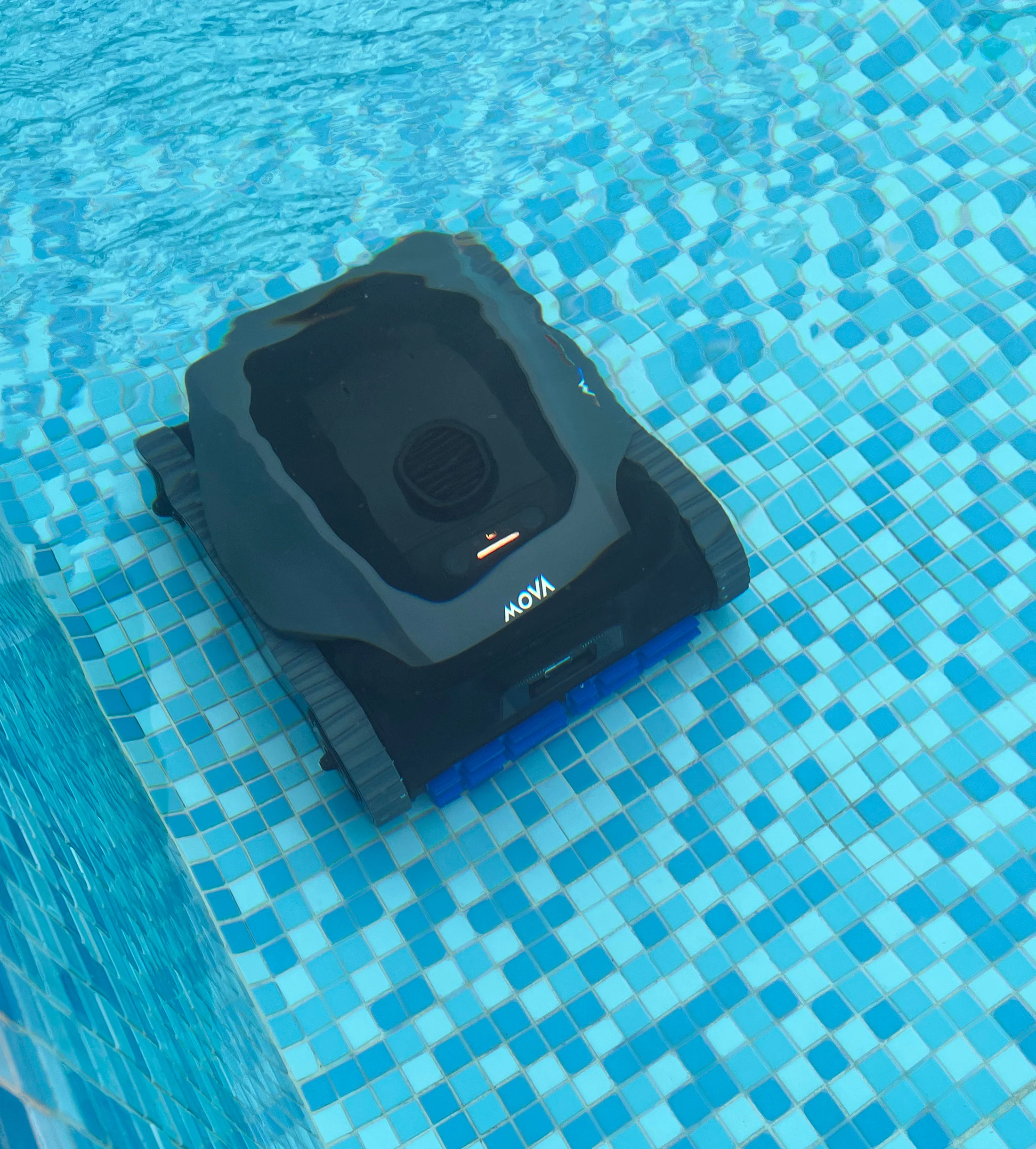 Ein schwarzer Poolreiniger mit blauen Bürsten im blauen Wasser.