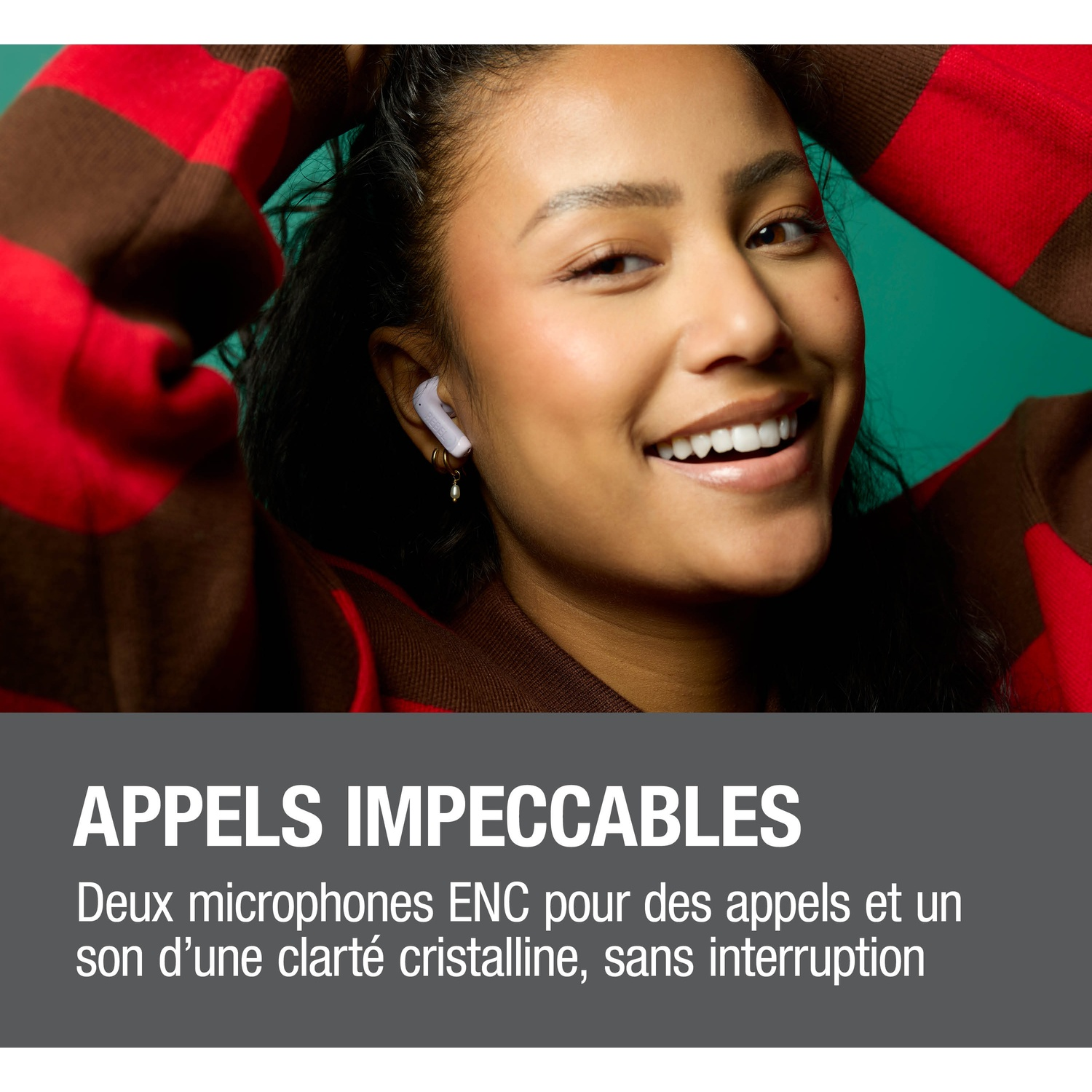 Femme avec écouteurs sourit ; pull rouge, fond bleu.