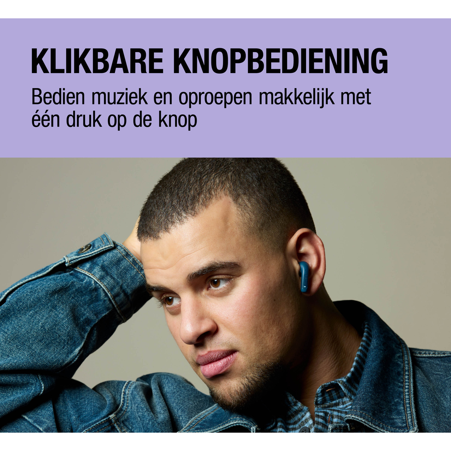 Man with a blue earbud in his ear, wearing a denim jacket.
