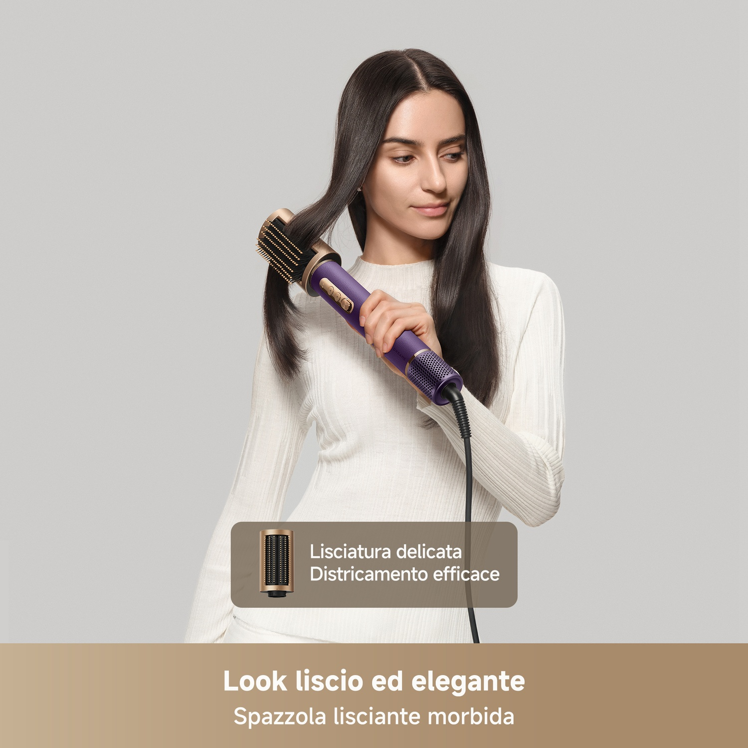 Una donna acconcia i suoi lunghi capelli scuri con un arricciacapelli viola su sfondo grigio.
