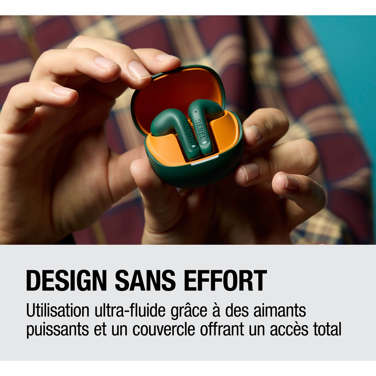Écouteurs verts et orange dans un étui de chargement tenu par des mains.
