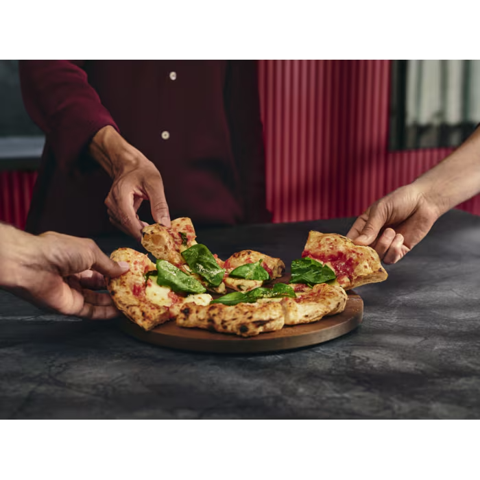 Kezek pizzadarabokat vesznek el, spenóttal és mozzarellával.